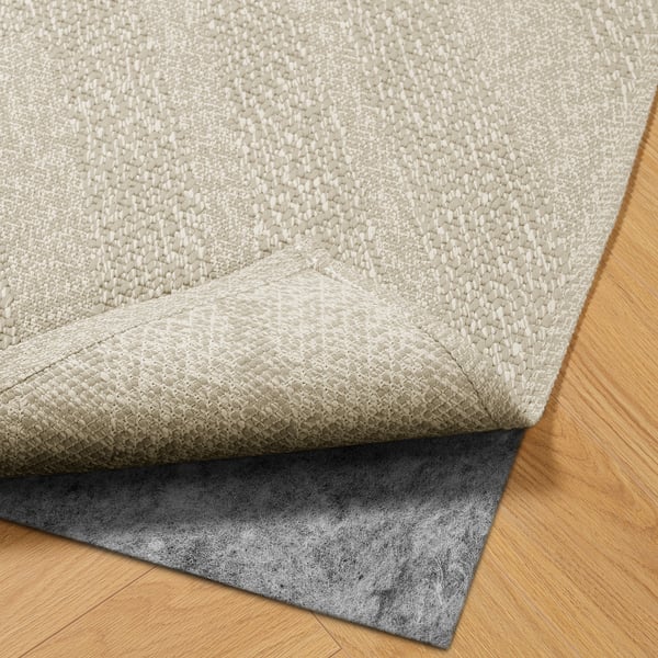 Beige textured rug with anti-slip black pad, suitable for indoor/outdoor use.