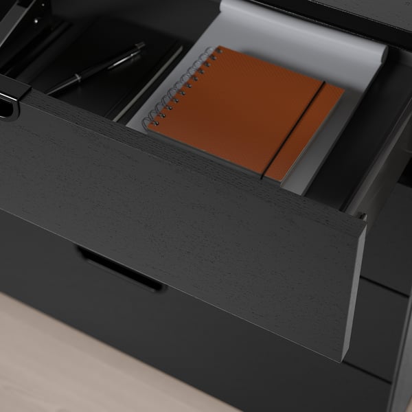 Black desk drawer unit with orange notebook and pen, lockable, with 10-year guarantee.