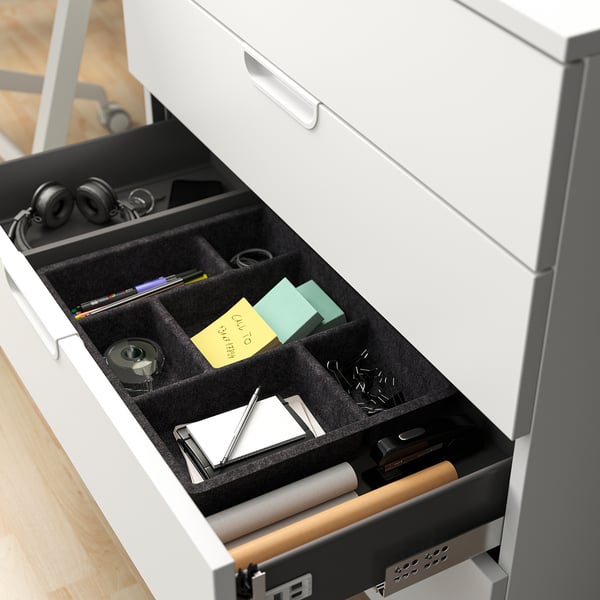 Desk drawer with organised office supplies, including headphones and notepads, showcasing GALANTs secure storage solution.