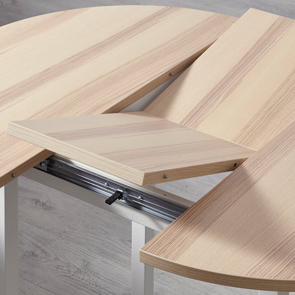 Extendable dining table shown with wooden segments and metal rail, highlighting sturdy construction and smooth extension mechanism.
