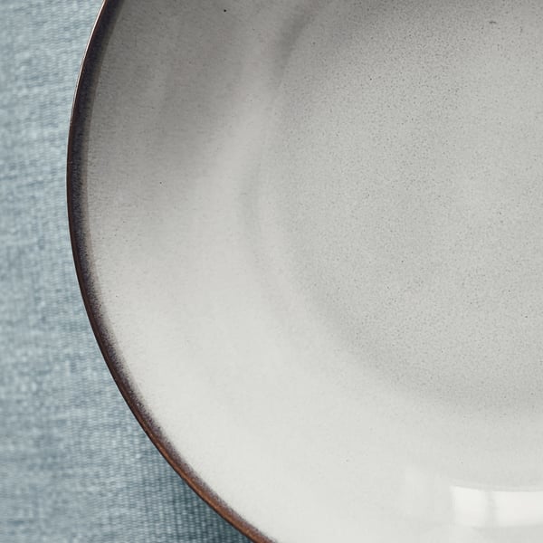 Handcrafted stoneware plate on blue cloth.