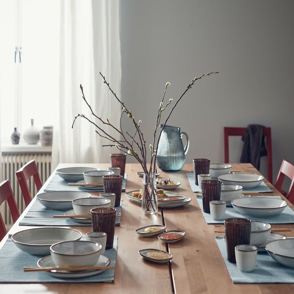 Dining table set with GLADELIG stoneware, branch centrepiece.