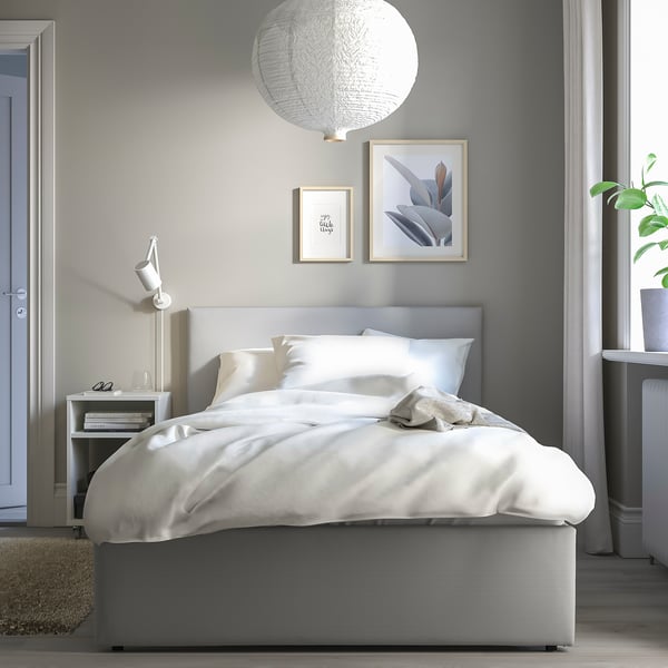 Minimalist bedroom with GLADSTAD bed, white linens, hanging light, art, nightstand, plant.