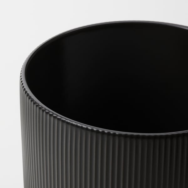 Black vase with vertical grooves.