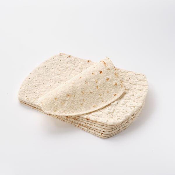 Stacked light beige flatbreads on white background.