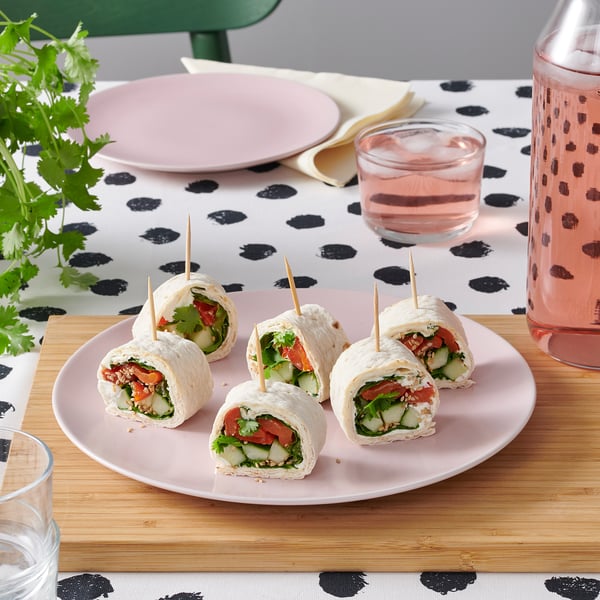 Plate of veggie wraps and drink on polka dot tablecloth.
