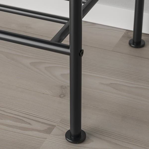 Close-up of a sturdy metal table leg on a wooden floor, showcasing industrial design and quality construction.