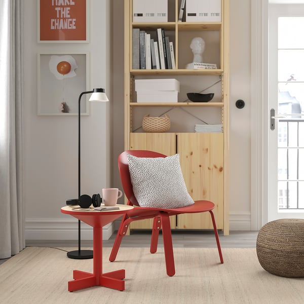 Bright red scandinavian-style grimsaebo side table next to a red chair. Small, modern, metal and wood, fits neatly beside furniture.
