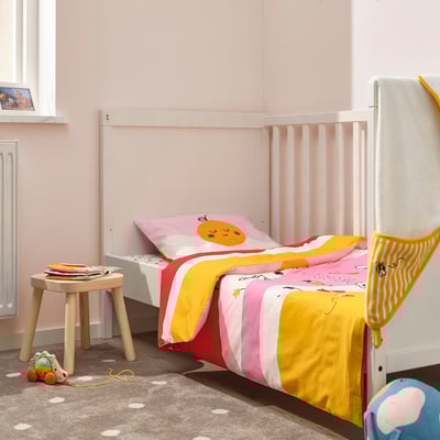 Cosy kids room with GRÖNFINK striped duvet, toy, and pink walls.