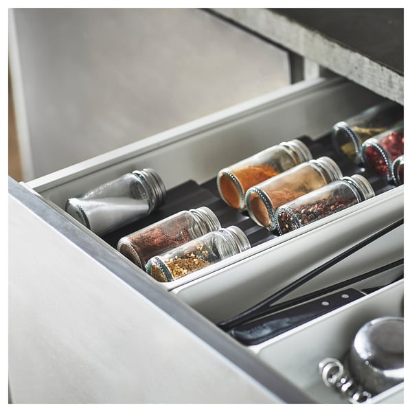 Spice jars in drawer, clear glass, stainless lids, organised, kitchen storage.
