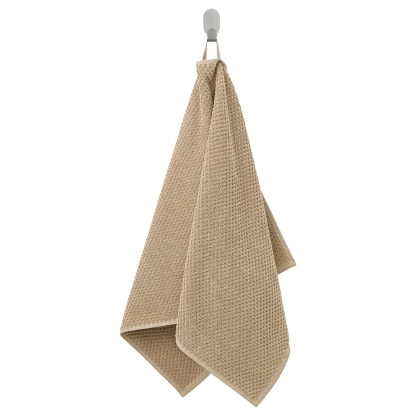 A beige GULVIAL towel hanging, rectangular, soft cotton, medium thickness, white hook at top.