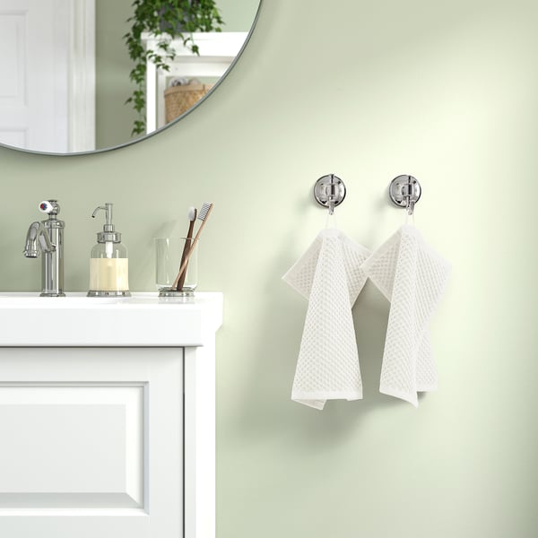 Bathroom with green walls, white sink, GULVIAL towels, and mirror reflecting greenery.