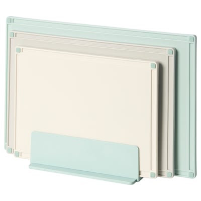 Three pastel colour cutting boards in light green, white, and light blue stand upright in a holder, ideal for kitchen use.