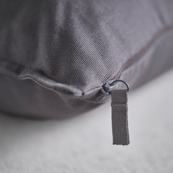 Zip detail on grey fabric cushion cover; close-up of recycled cotton material.