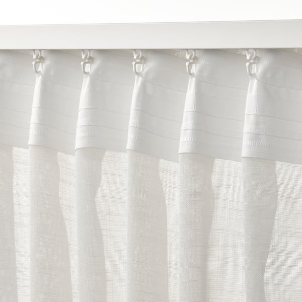 Sheer white curtains with hooks, pleated for privacy yet daylight.