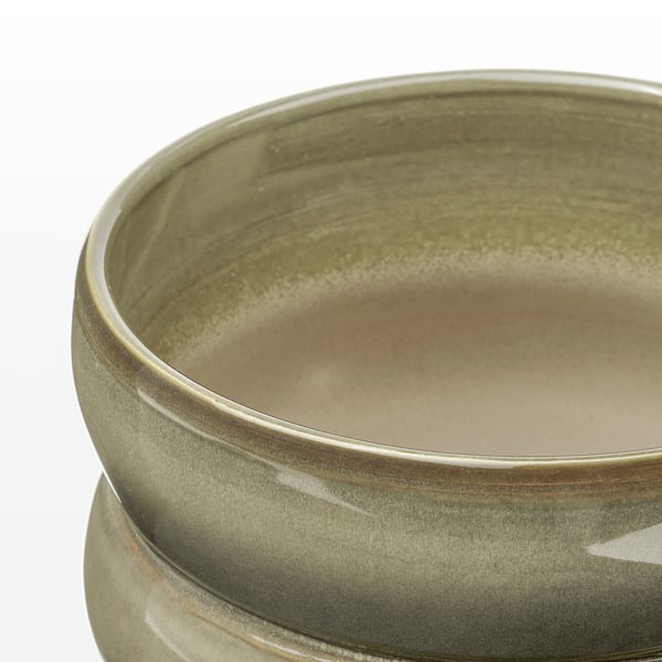 Close-up of green glazed bowl on white background.