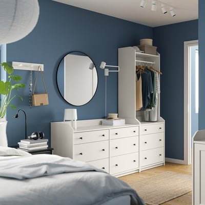 Blue bedroom with HAUGA chest, mirror, wardrobe, jute rug, plant, light wood floors.