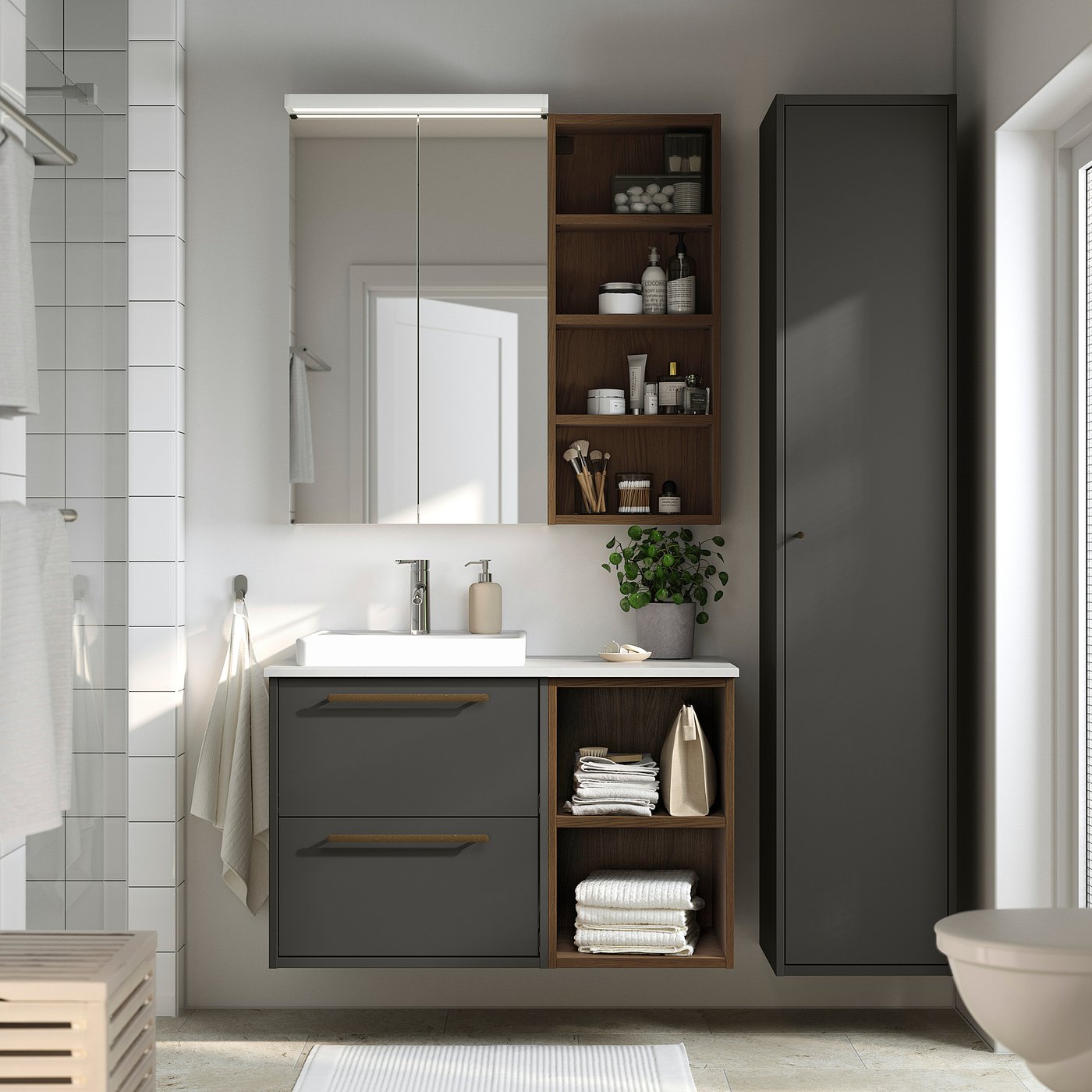 Modern grey vanity with open/closed storage, sleek design, ceramic basin, wood shelves, wall-mounted, mirror with light, plant, towel.