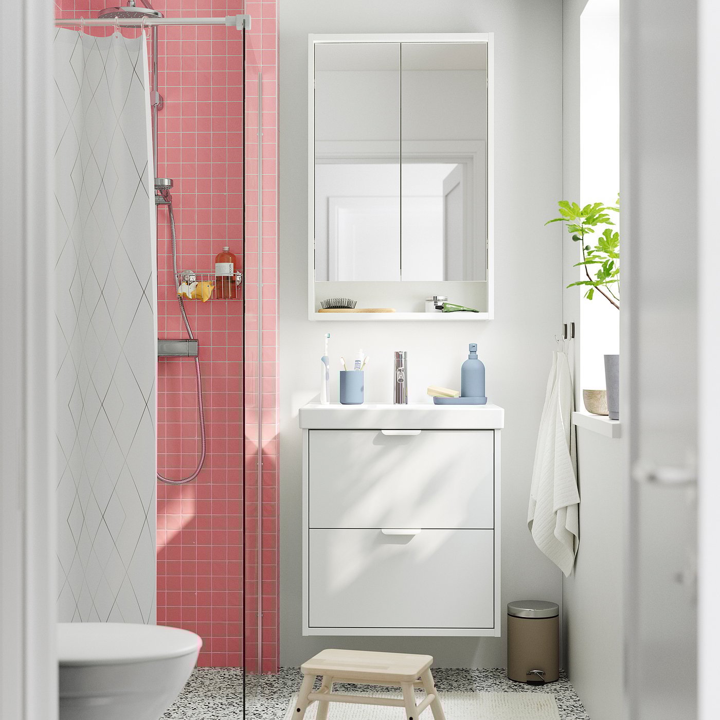 Modern bathroom with HAVBÄCK vanity, drawers, pink shower tiles, mirror cabinet, step stool.