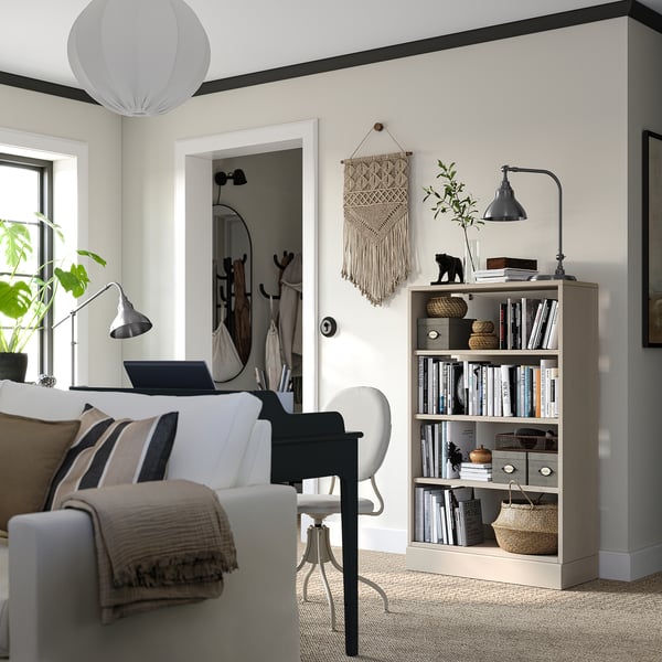 Minimalist living room with HAVSTA shelves, books, decor, sofa, and laptop chair.