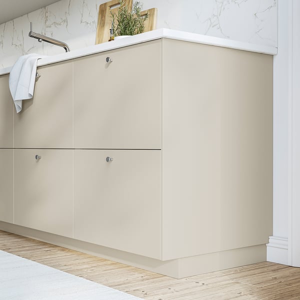 Beige HAVSTORP cabinet with smooth surfaces complements marble wall and wooden floors, offering ample storage for a modern bathroom.