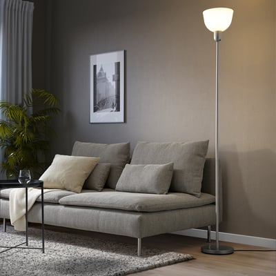 Modern living room with beige floor lamp, sofa, side table plant, and cityscape photo.