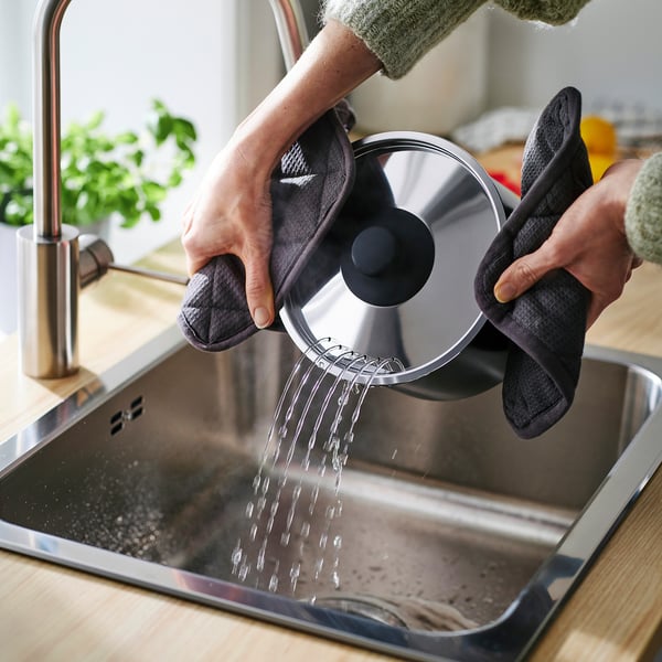 Pouring water with oven mitts.