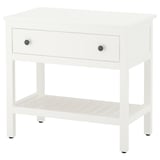 A white wooden HEMNES bedside table with a single drawer and an open shelf, featuring stylish round knobs.