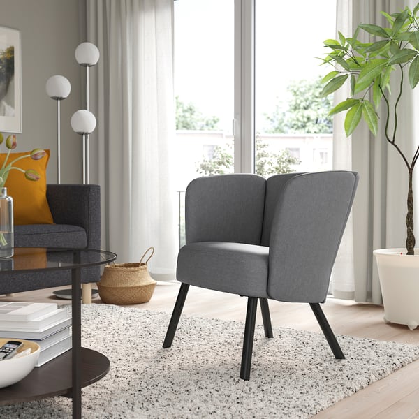 Modern grey HERRÅKRA armchair with black legs in living room.