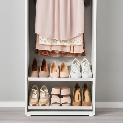 Closet organiser with shoe shelves and hanging rod. Shoes and garment displayed neatly.