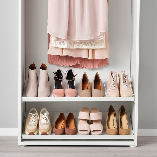 A shoe rack organises various footwear inside a closet, keeping them tidy and accessible.