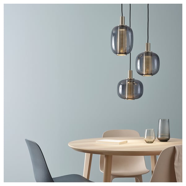 Modern dining setup with 3 pendant lamps, blue wall.