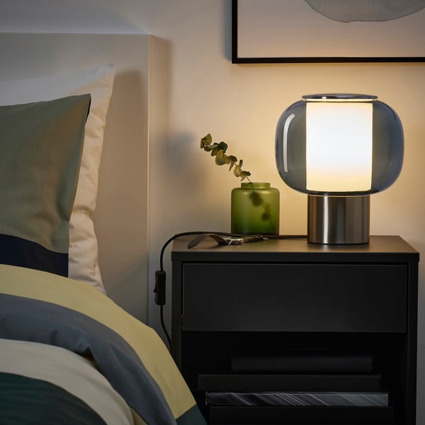 Blue lamp on bedside, warm light, modern decor.