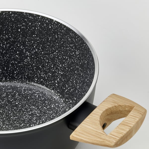 Close-up of a modern saucepan with a non-stick interior and wooden handle.