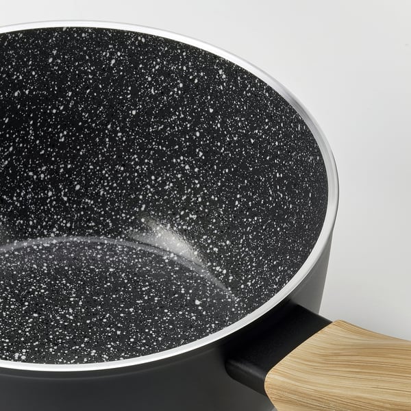 Black saucepan with speckled non-stick interior, wooden handle.