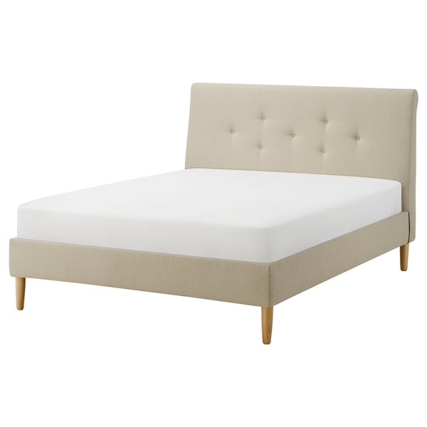 A beige IDANÄS bed with a tufted headboard and wooden legs.