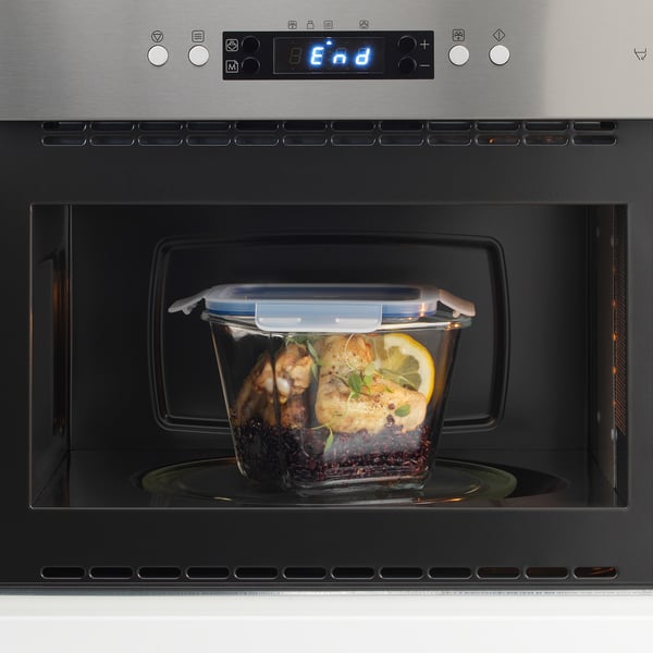 Glass container with food in microwave. Digital display reads end, indicating cooking is complete.