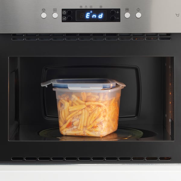 Container of food heating in microwave, displaying digital timer reading end.