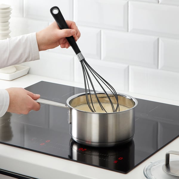 Whisking sauce on modern stove.