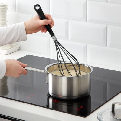Whisking sauce on modern stove.