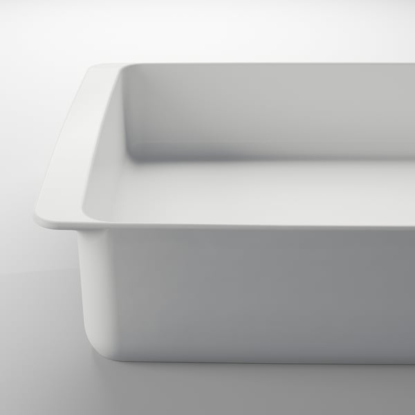 White porcelain baking dish, rectangular, smooth surface, strong handles, clean.