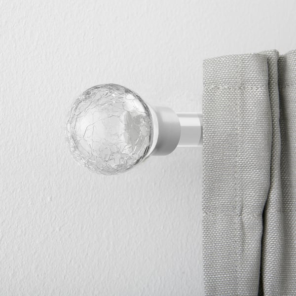A spherical glass finial on a curtain rod, serving as a stylish end piece to enhance window treatments.
