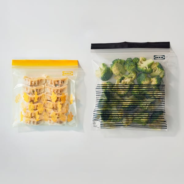 Two zip bags: one filled with dumplings, the other with broccoli and green beans.
