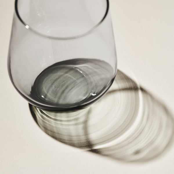 Clear glass with broad rim and base, casting circular shadows, reflects quality and elegance.