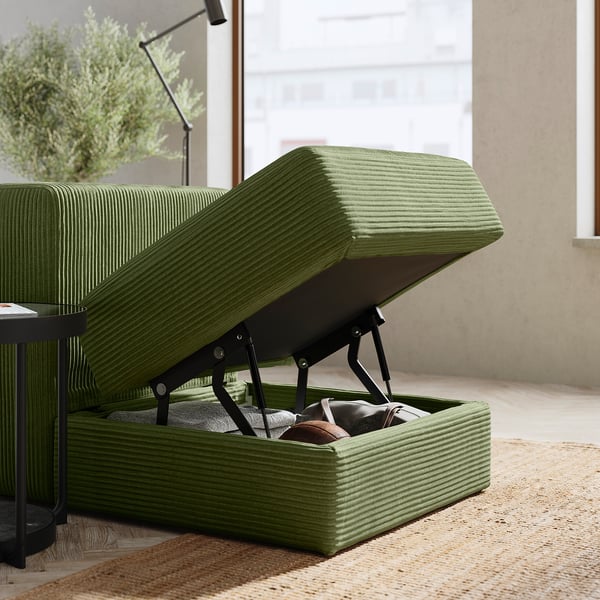 Green JÄTTEBO sofa with lift-up seat revealing storage, modern design.