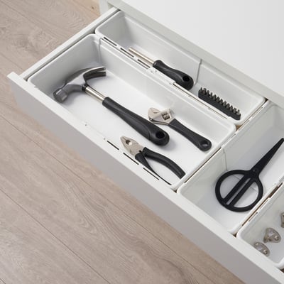 White toolbox with black tools. Hammer, wrenches, pliers, and scissors organised inside.
