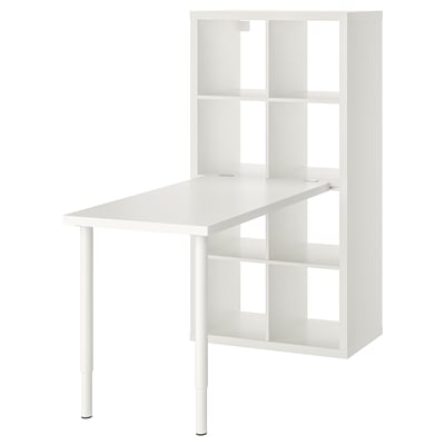 A white ikea KALLAX unit with a tabletop, combining storage and workspace. Its rectangular, simple, and modern, featuring multiple open compartments.