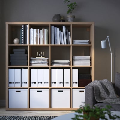 KALLAX shelving unit with books, plants, and storage boxes.