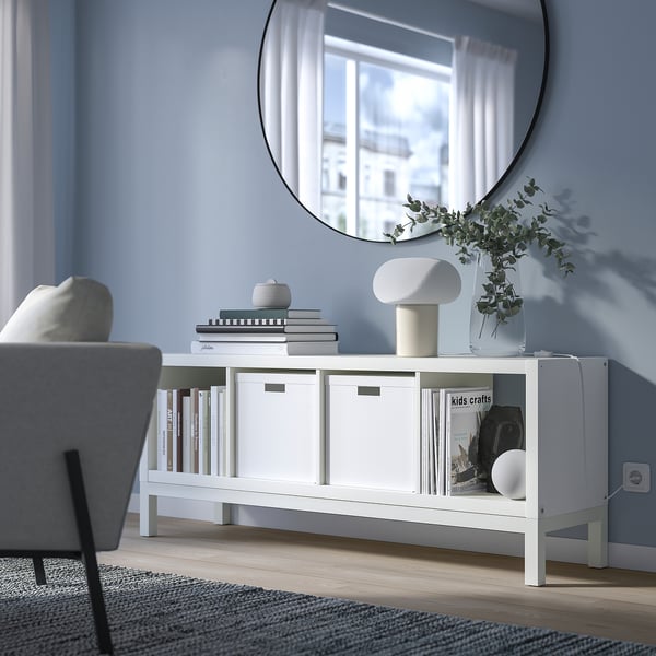 KALLAX shelf against blue wall, mixed storage, mirror above.