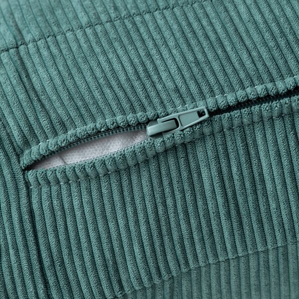 Close-up of teal green KIVIK sofa zip, showcasing texture and quality of soft, thick fabric.